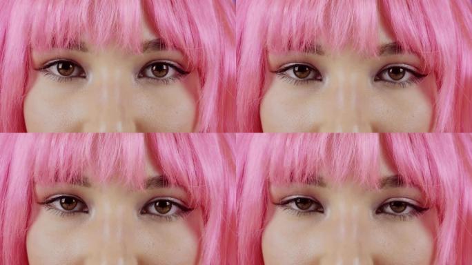 美丽的粉红色头发的年轻女子看着镜头。