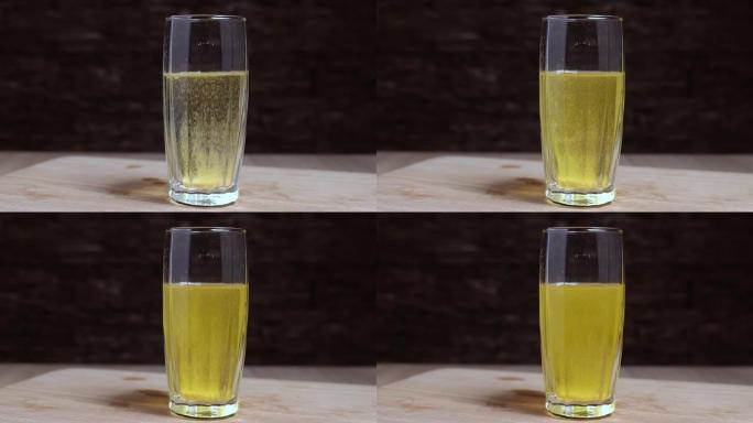 将维生素c药丸扔进玻璃杯中。药丸起泡，使水充满黄色。