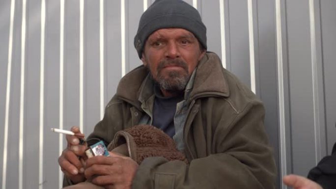 无家可归的人抽烟，在户外聊天。无家可归的问题。