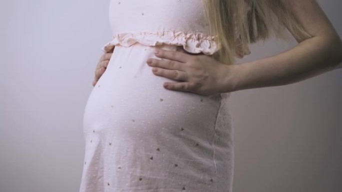 孕妇在白色背景特写中抚摸肚子
