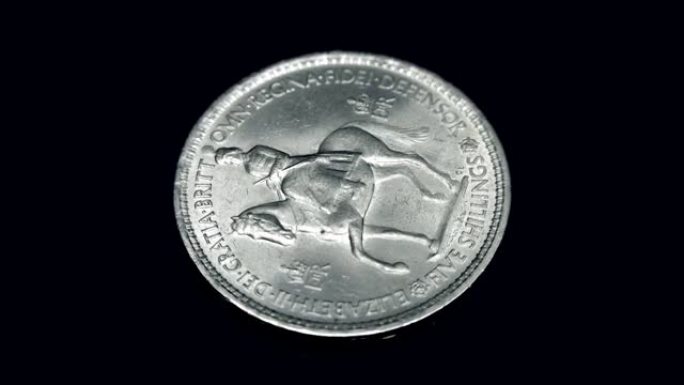 英国硬币五先令在黑色背景上旋转。宏观。特写