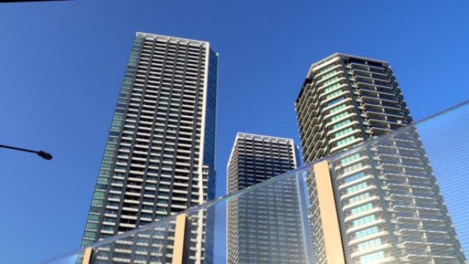蓝天背景下的现代高层公寓楼。平移镜头。
