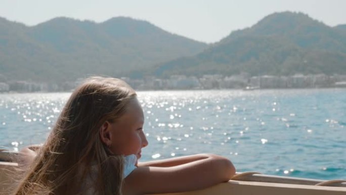 沉思的女孩坐在船上，在海上旅行中看着水