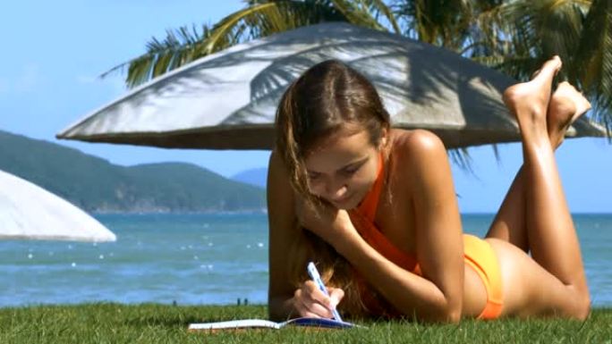 躺在草地上的女士在纸质书中写道