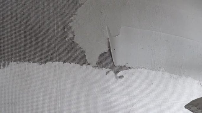 用尼龙网将腻子粉铺在墙上