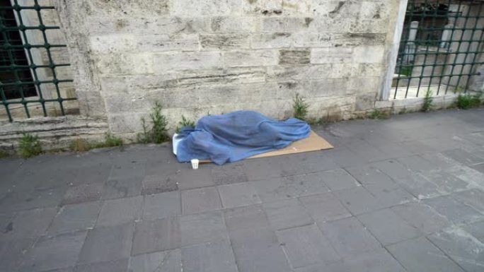 伊斯坦布尔，被遗弃的无家可归的人在寒冷的天气下在毯子下和平地睡在人行道上，在Sehzade Cami