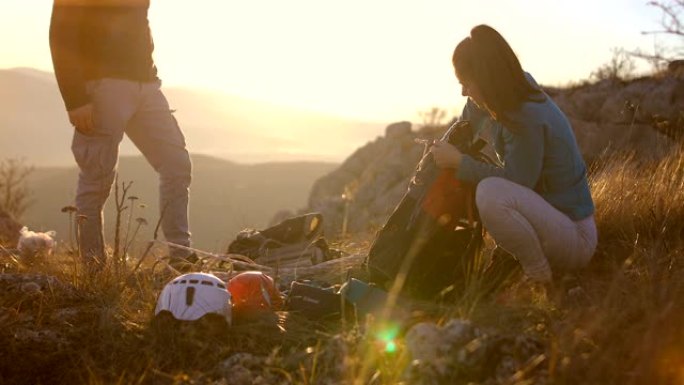幸福的年轻夫妇收拾背包在阿尔卑斯山远足。背景中的塑料袋