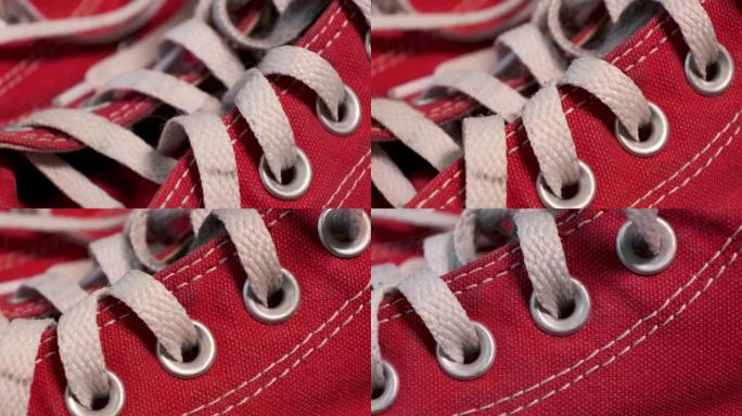旋转一双红色二手运动鞋的特写镜头，搭配白色鞋带。运动鞋，青春时尚理念。