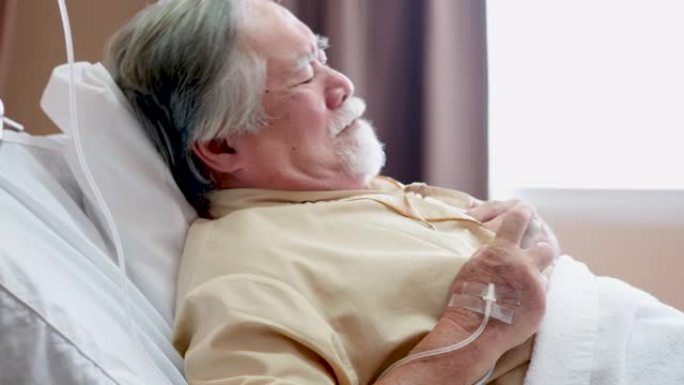 有心脏病的高龄患者躺在床上康复室有反复发作的疾病，胸闷，按下紧急按钮，打电话给医生和护士。医学、保健