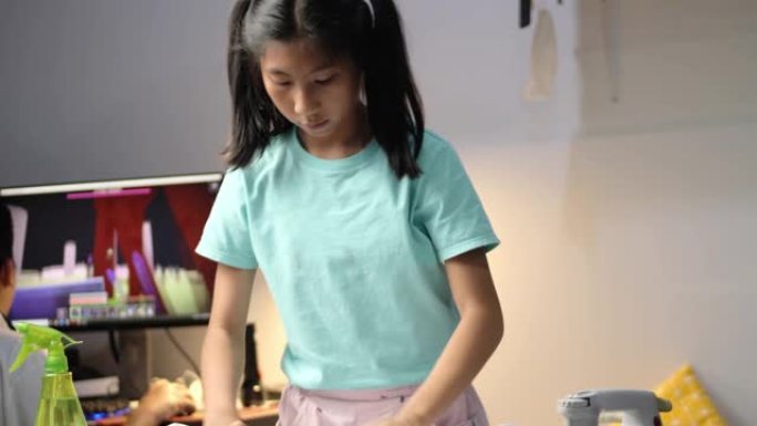 亚洲女孩晚上在家熨烫学生服。