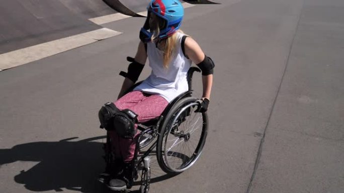 坐在轮椅上的残疾妇女在滑板公园做特技