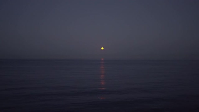 黄昏中满月在海上升起，浪漫的场景
