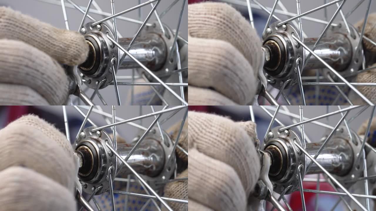 自行车的维修和保养。一个男性修理工在轮毂轴上拧紧螺母的极端特写镜头。安装自行车的前轮。