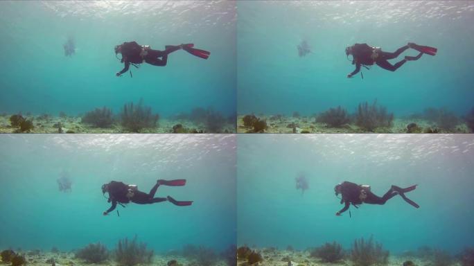 漂浮在水中的女性潜水员。侧视图