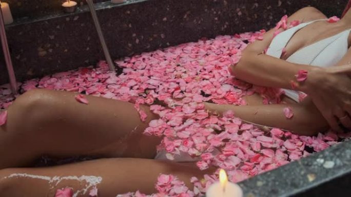 水疗中心，面目全非的女性正在浴缸里用花瓣放松