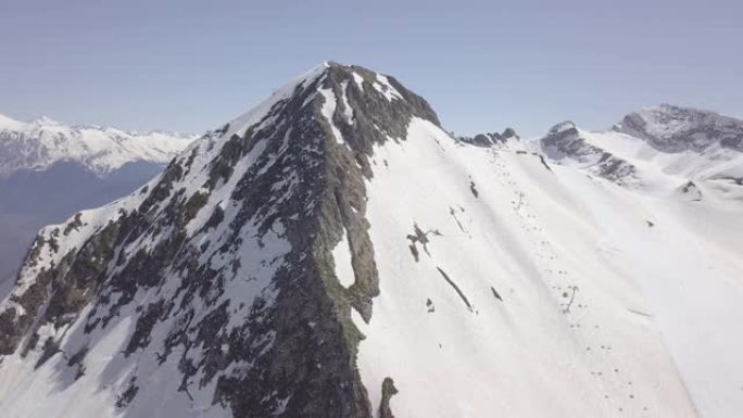 俄罗斯索契克拉斯纳亚波利亚纳洛基高加索山脉白雪皑皑山峰的鸟瞰图。晴朗的蓝天，云，冬天，春天。风景优美