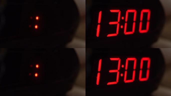 黑色数字时钟屏幕的特写显示13.00。黑色背景上闪烁红色数字。现代定时器系统和霓虹灯、电动报警装置