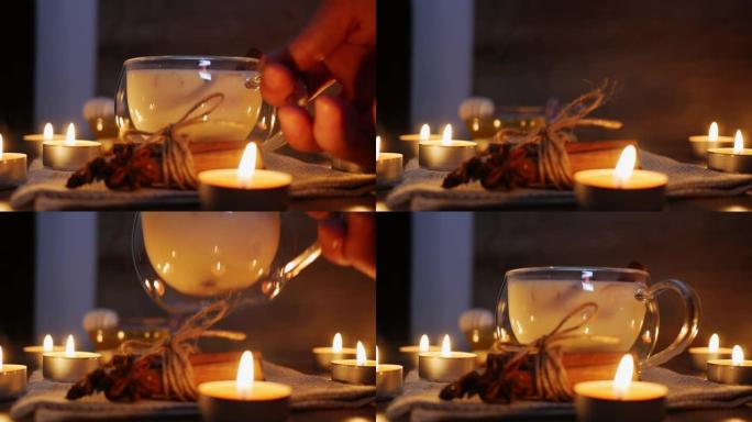 放一杯传统的印度马萨拉柴茶在烛光下点燃。印度masala chai茶-带有牛奶的五香茶，以质朴的木制