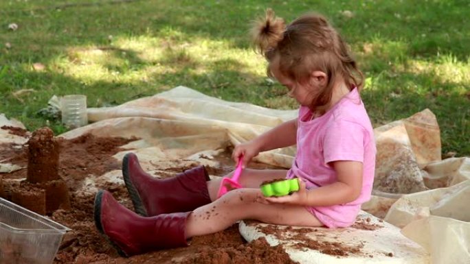 小女孩在后院玩沙子