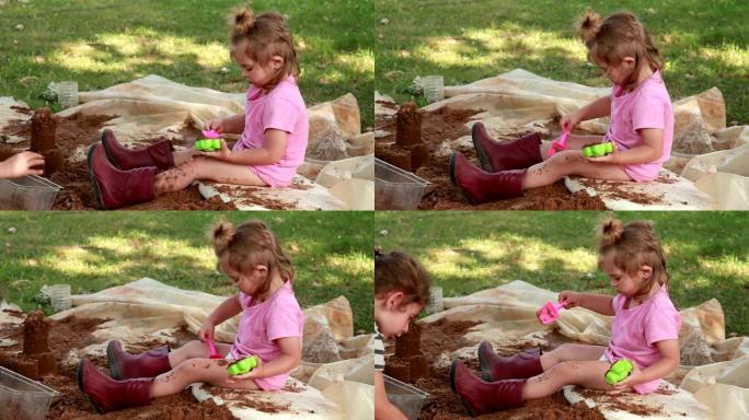 小女孩在后院玩沙子