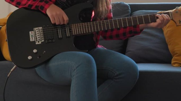 十几岁的女孩在电吉他上学习和弦