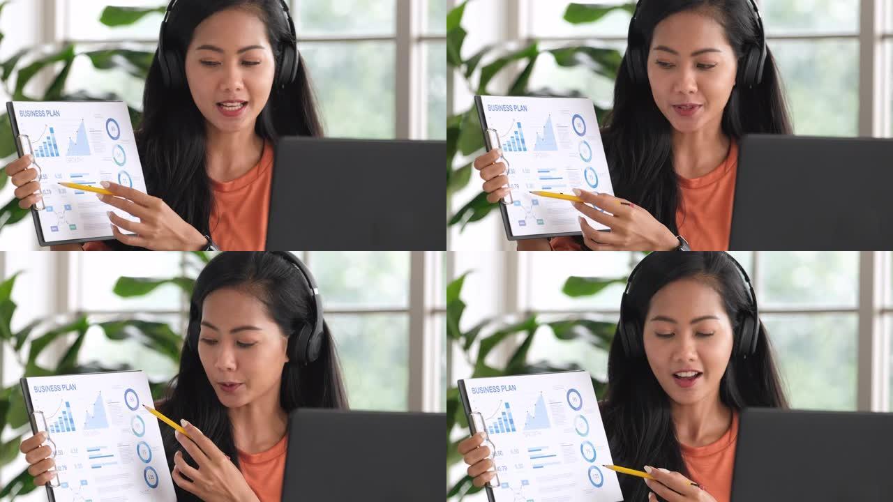 亚洲女性在视频会议上展示项目，在家中使用笔记本电脑。新的正常办公室生活概念