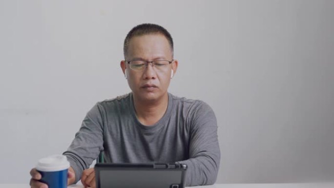 40-50岁的亚洲男性正在视频通话，开会，聊天或在线学习。呆在他家