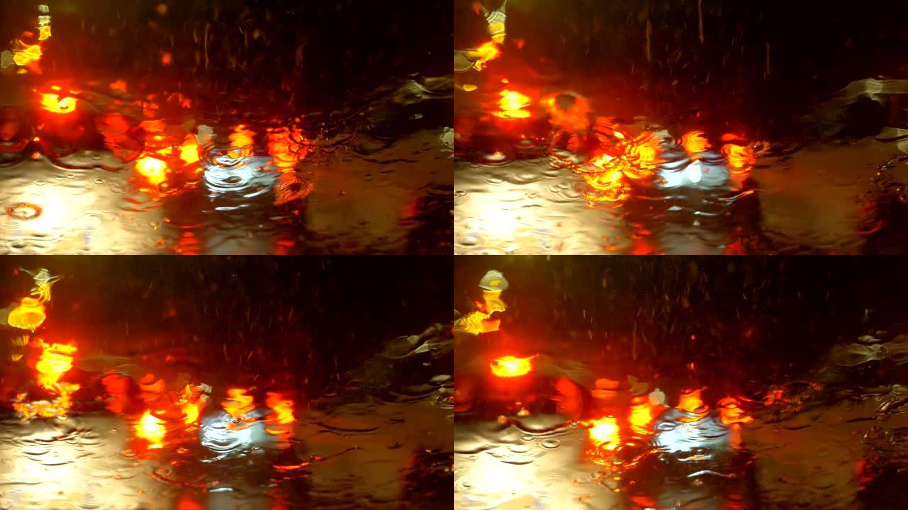 在雨夜里在城市里开车。汽车挡风玻璃上的大雨