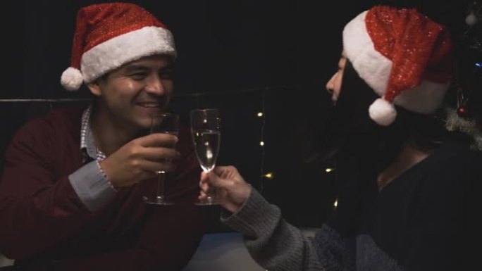 幸福的情侣情人派对和香槟一起欢呼，在餐厅庆祝圣诞晚餐