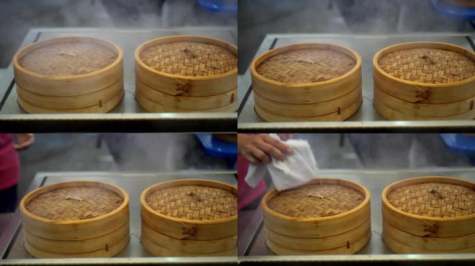 厨师在蒸锅中餐中打开点心竹篮
