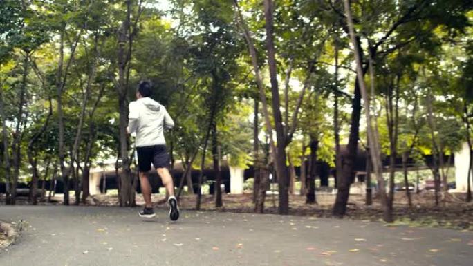 年轻人运动员在公园里跑步，享受美丽的森林。