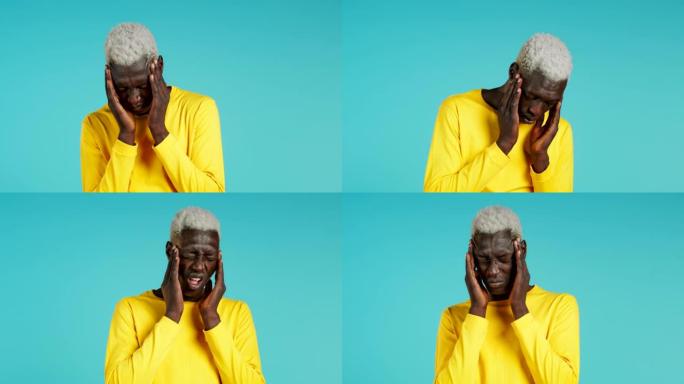 年轻的非洲裔美国人头痛，工作室肖像。家伙把手放在头上，孤立在蓝色背景上。问题、医学、疾病的概念