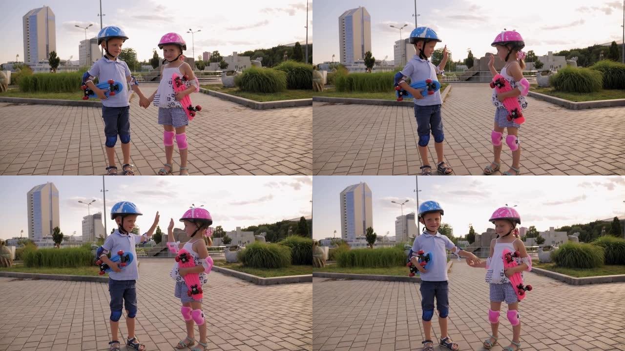 戴着头盔的可爱的小孩带着滑板在公园散步。