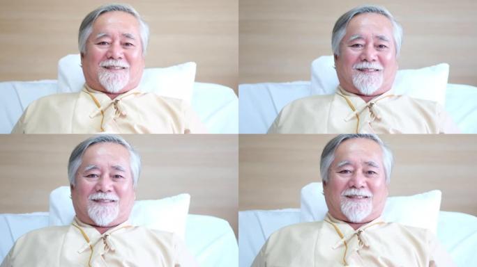 亚洲老年患者躺在康复室的床上，看起来很放松，对治疗后病情好转感到高兴。退休后的老年保健支持理念，药物