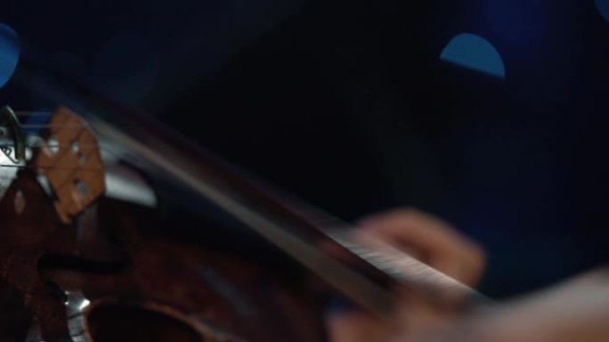 细节镜头，小提琴家男人在舞台上的表演，浅色，深色背景