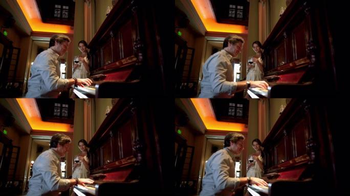 英俊的男人在餐馆为妻子弹钢琴