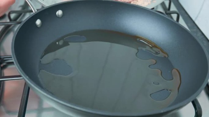 摊开/摇动平底锅，以便在4k内用油覆盖整个底部表面。摆动pon到底部的概念。
