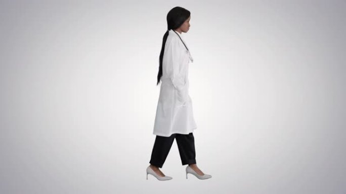 悲伤的非洲裔美国女医生在渐变背景上双手插在口袋里走路