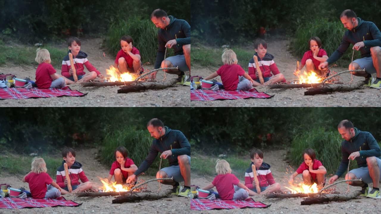 家庭，孩子在夏季河边的傍晚野餐和篝火