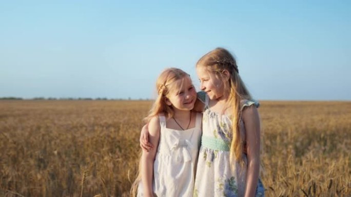 乡下的女朋友，两个长发的女孩子互相拥抱，看着蓝天背景下麦田上的相机