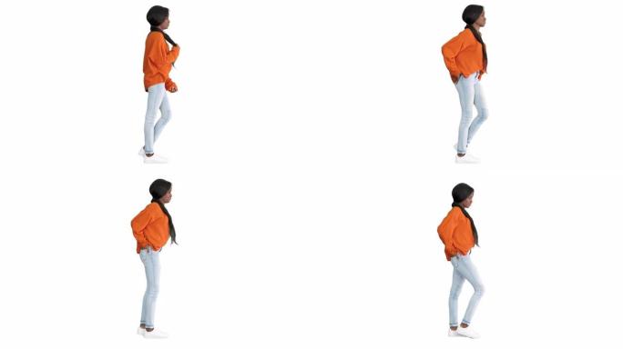 微笑的非洲裔美国妇女穿着明亮的毛衣和牛仔裤，双手插在白色背景的口袋里摆姿势