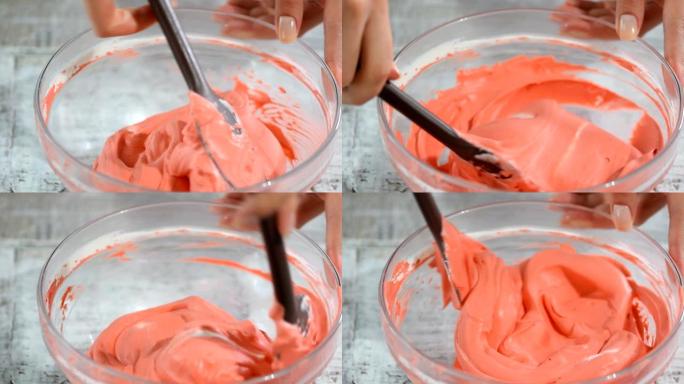 在搅拌碗中手动搅拌粉红色奶油。