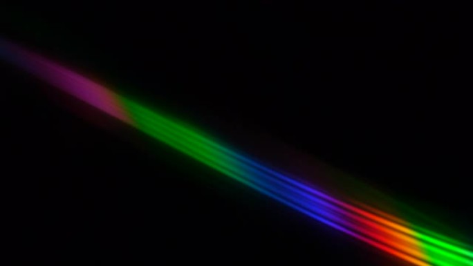 黑色背景上的彩色光束和光线。光盘上的抽象背景彩虹。美丽的彩色镜头灯光彩虹光束，用于晚上的电影和电影。