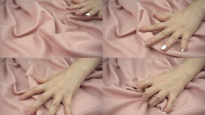 在慢动作中触摸敏感织物。女人的手轻柔地抚摸着纺织品，并充满激情地挤压它。