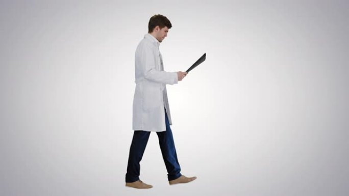 集中男性医生在梯度背景上行走时检查计算机断层扫描