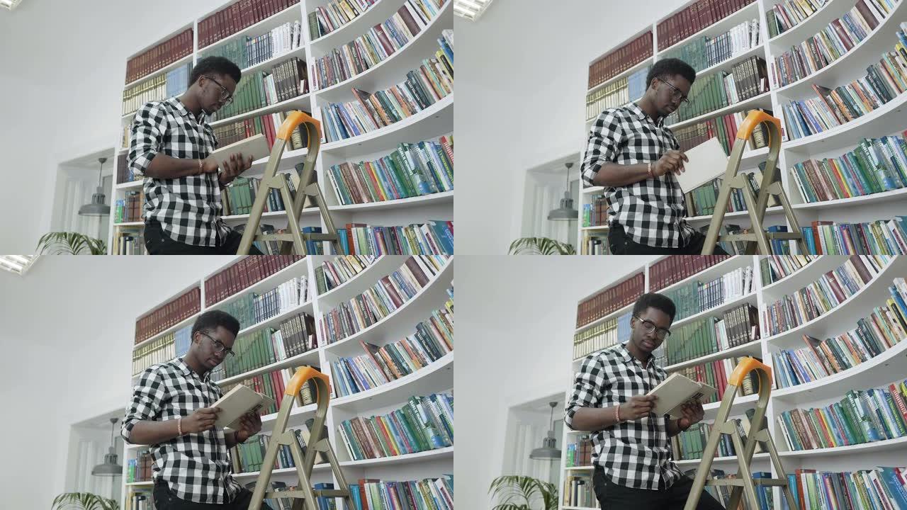 非洲男学生站在大学图书馆的梯子上时从书架上看书