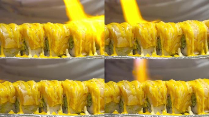 厨师拿着厨房喷灯的慢动作，在餐厅厨房的日本料理表面燃烧