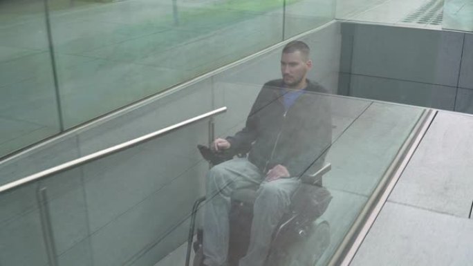 4k分辨率跟随一个坐在电动轮椅上的人使用坡道。无障碍概念
