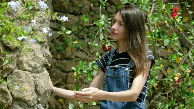 在巴塞罗那的奎尔公园，一位迷人的年轻女子深深地吸着花香。西班牙4 k。