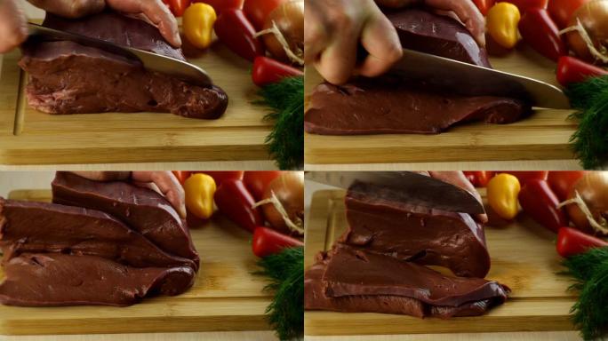 厨师的手用锋利的菜刀在木制厨房板上切生牛肝。
